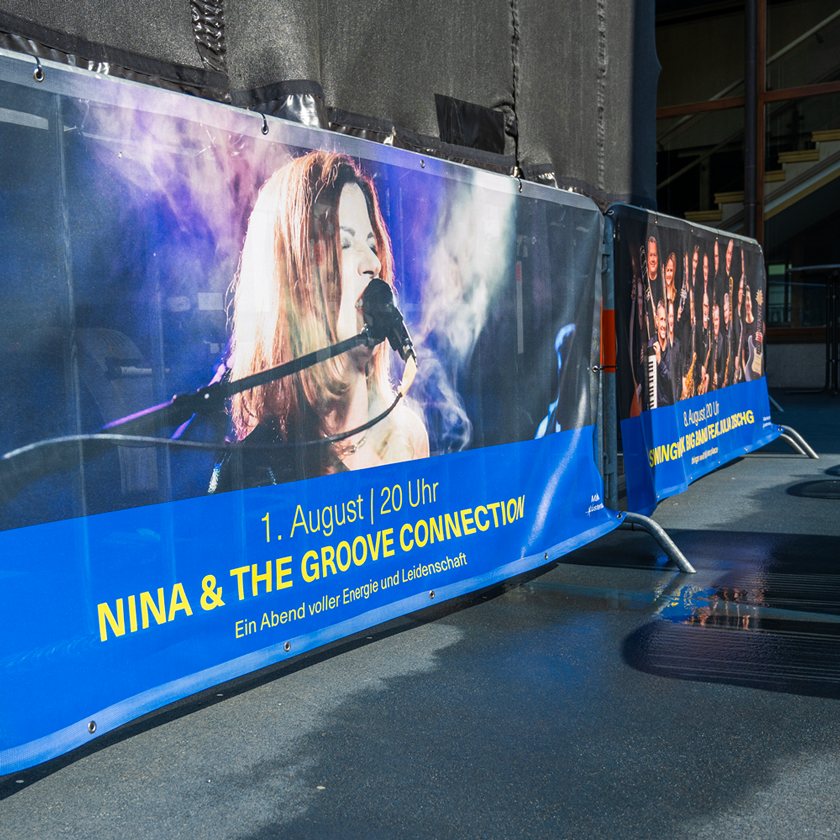 Sommer am Platz Absperrgitter blau und gelb